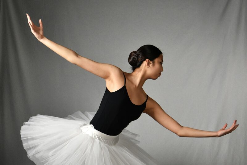 Ballet dancer in a white tutu holding an extended pose