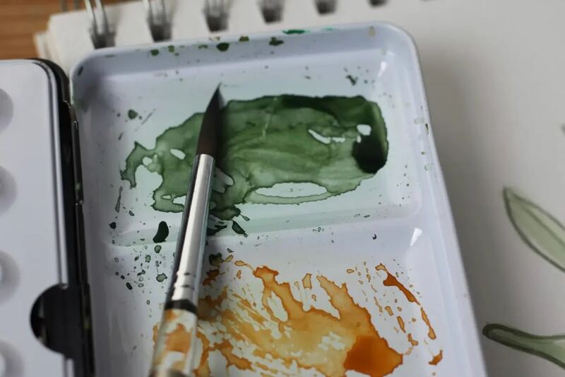 Painting materials and a work in progress on an easel