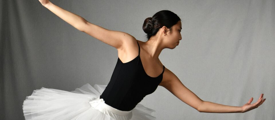 Ballet dancer in a white tutu holding an extended pose