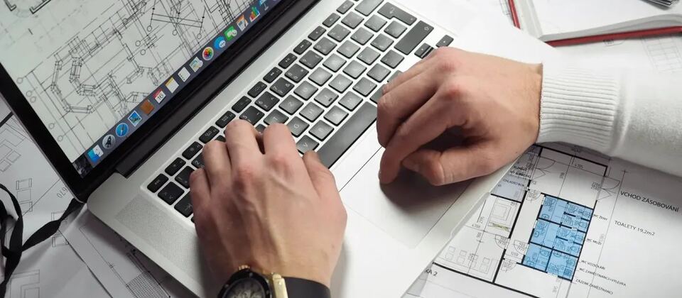 Interior designer working with laptop and floor plans