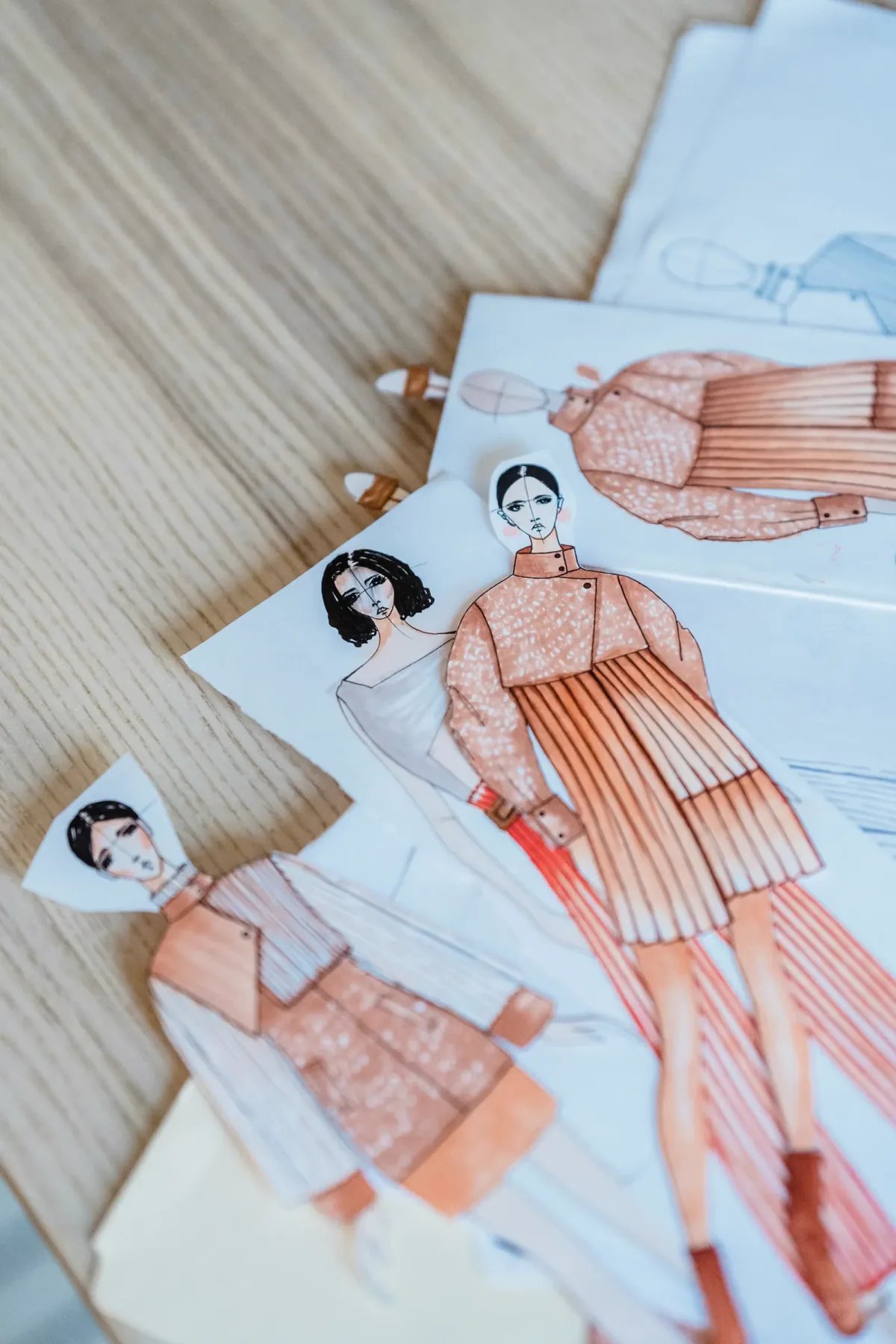 Elle moda eskizi çizen bir tasarımcı