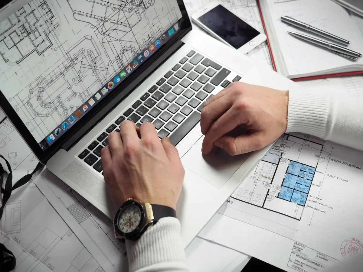 Interior designer working with laptop and floor plans