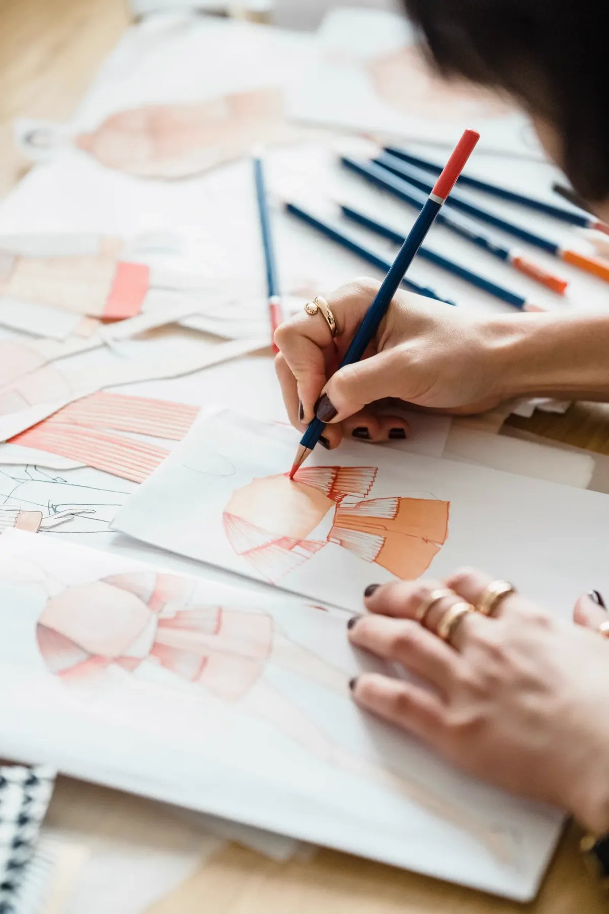 Fashion concept sketches spread on a desk