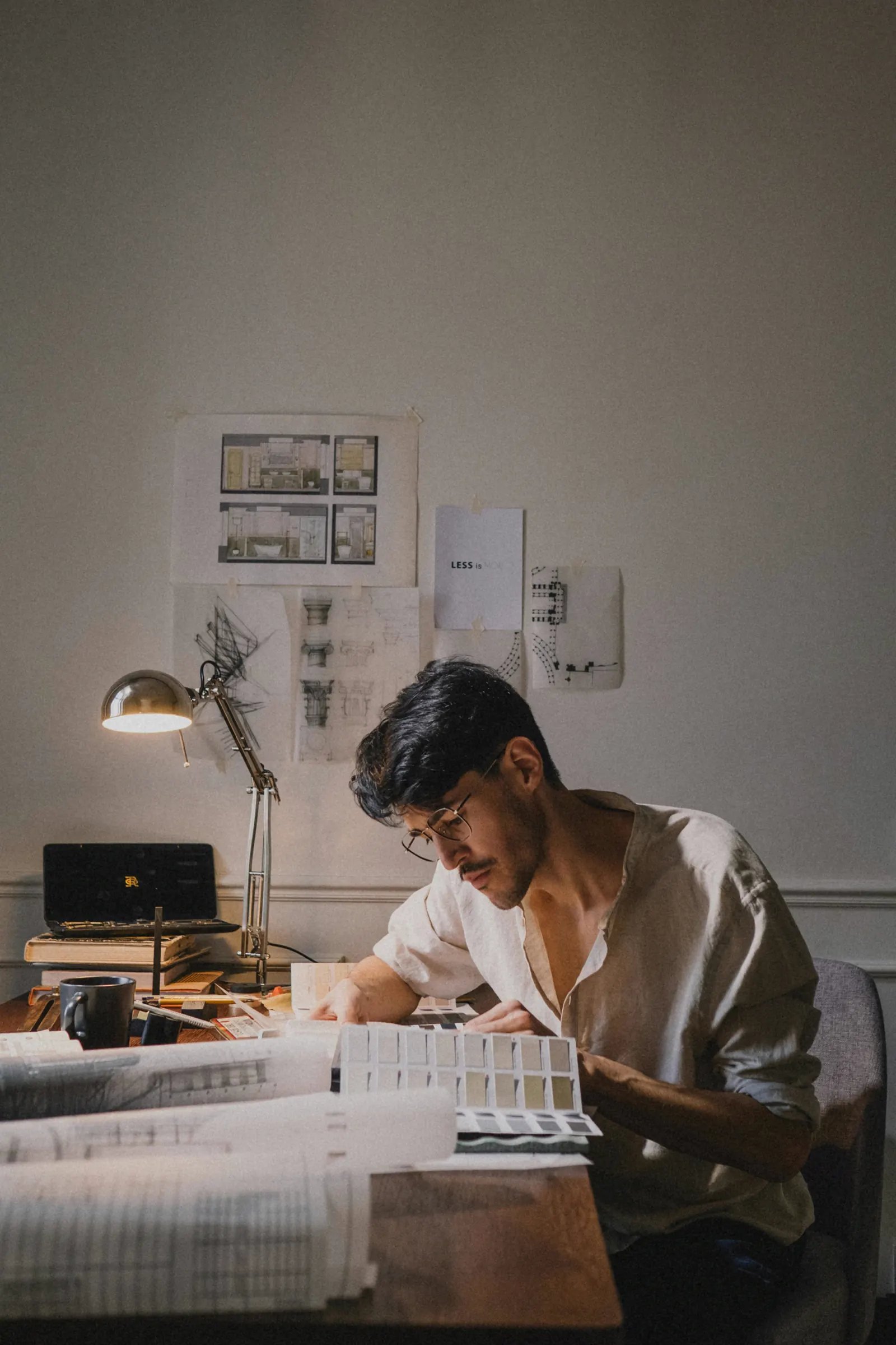 Designer working on drawings and material samples at a work desk